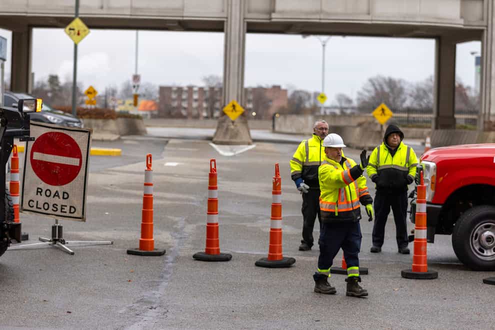 Workers block the entrance to the Rainbow Bridge border crossing between the US and Canada (Carlos Osorio/AP)