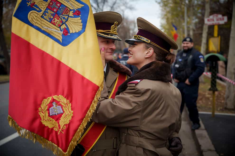 Military cadets hug before taking part in the National Day parade in Bucharest (Vadim Ghirda/AP)