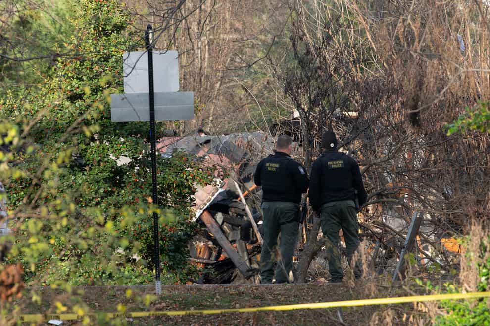 Members of the Arlington County Fire department looks towards the remains of a house explosion (Kevin Wolf/AP)