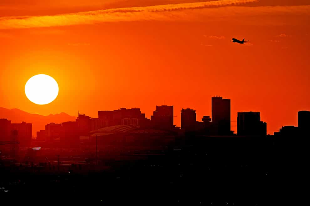 A jet takes flight from Sky Harbor International Airport as the sun sets over Phoenix, (AP)