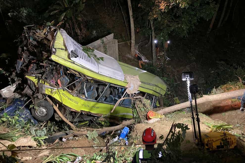 The bus lost control while negotiating a downhill curve and plunged into a deep ravine (Iloilo City Disaster Risk Reduction and Management Office – Urban Search and Rescue Unit via AP)