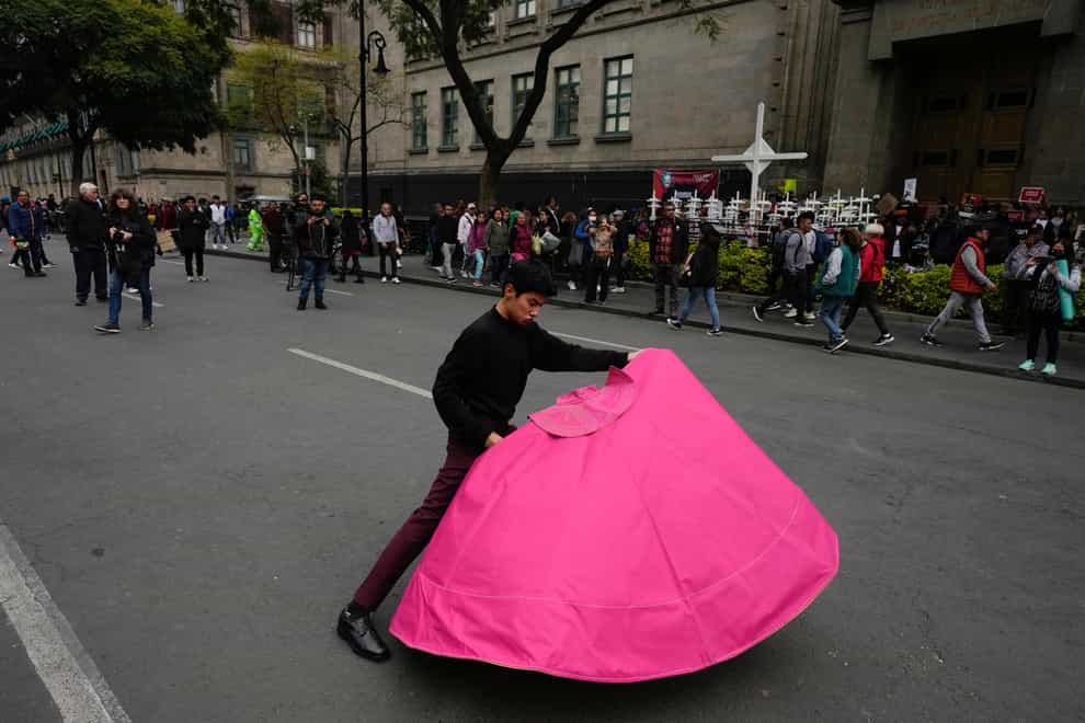 Juan Pablo Vargas makes matador cape movements during a demonstration outside the Supreme Court building in Mexico City (Fernando Llano/AP)