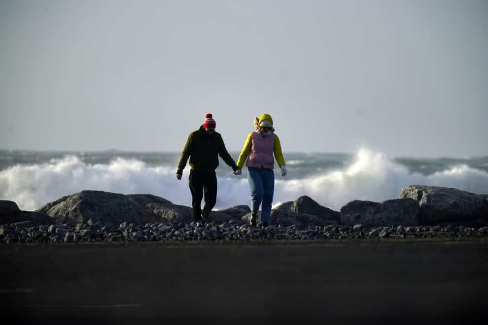 People walk along the seafront in Doolin in County Clare on the west coast of Ireland (Niall Carson/PA)