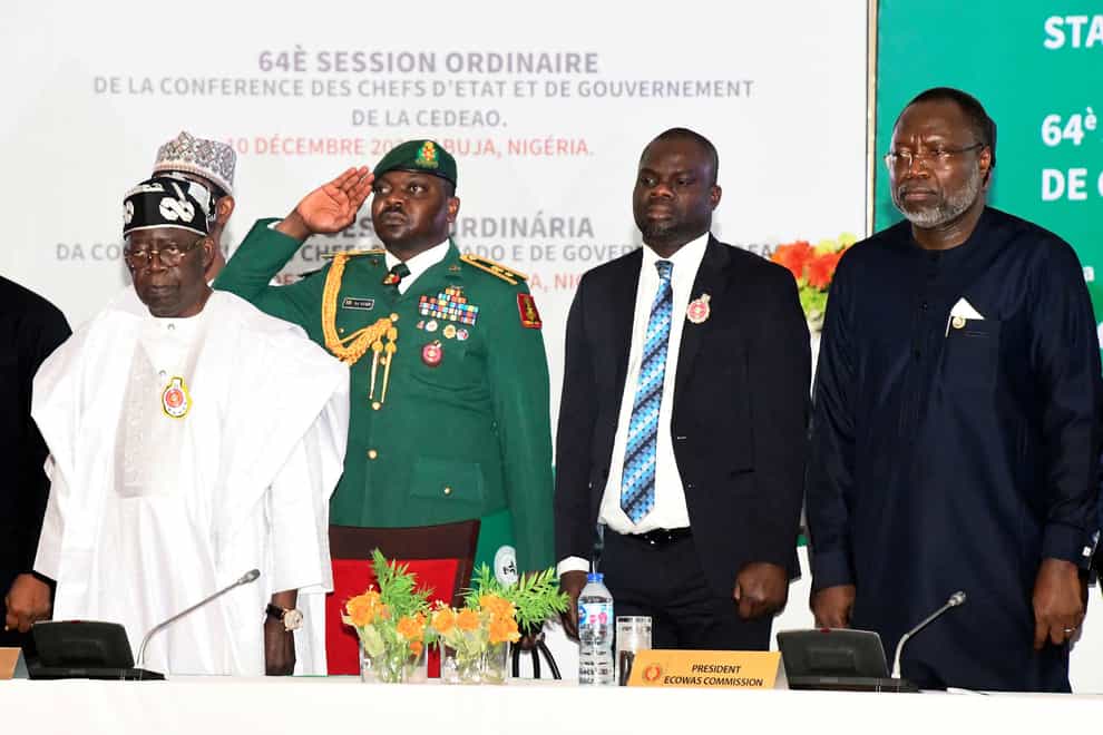 Nigeria’s President Bola Ahmed Tinubu, right, attends an ECOWAS meeting in Abuja, Nigeria, on Sunday (AP)