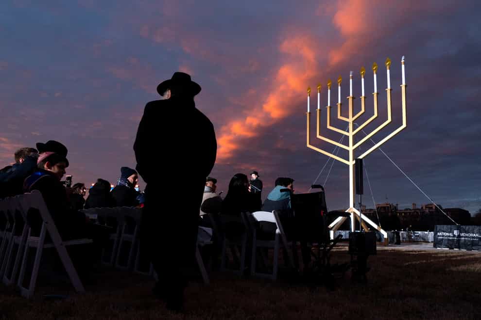 A man returns to his seat during the national Hanukkah Menorah lighting near the White House in Washington (AP Photo/Jacquelyn Martin)