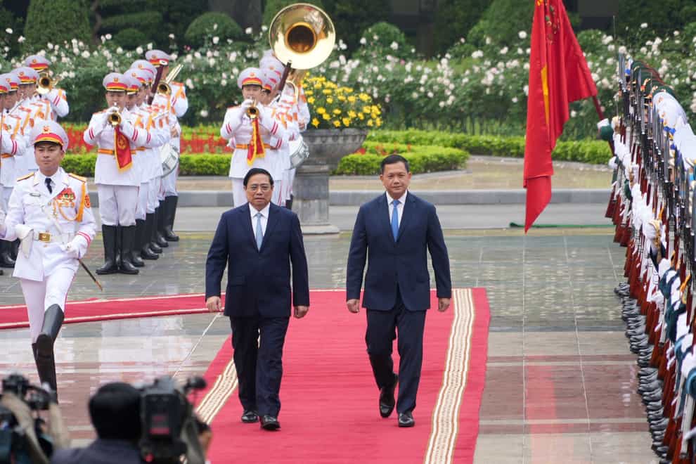 Vietnamese prime minister Pham Minh Chinh, left, and Cambodian prime minister Hun Manet inspect an honour guard in Hanoi (AP Photo/Hau Dinh)