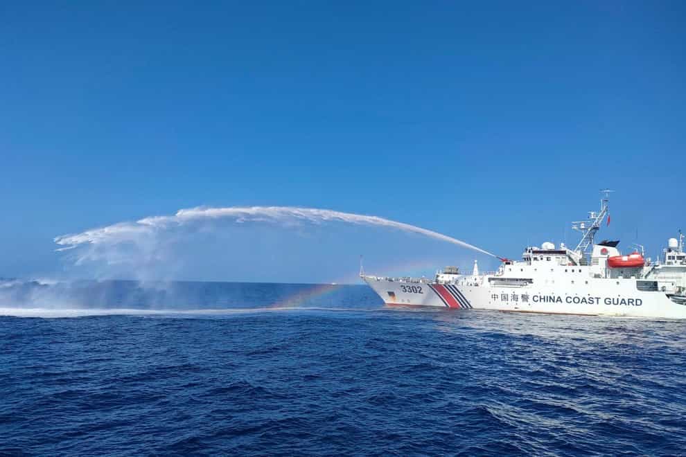 A Chinese coastguard ship, right, uses its water cannons on a Philippine vessel (Philippine Coast Guard via AP)
