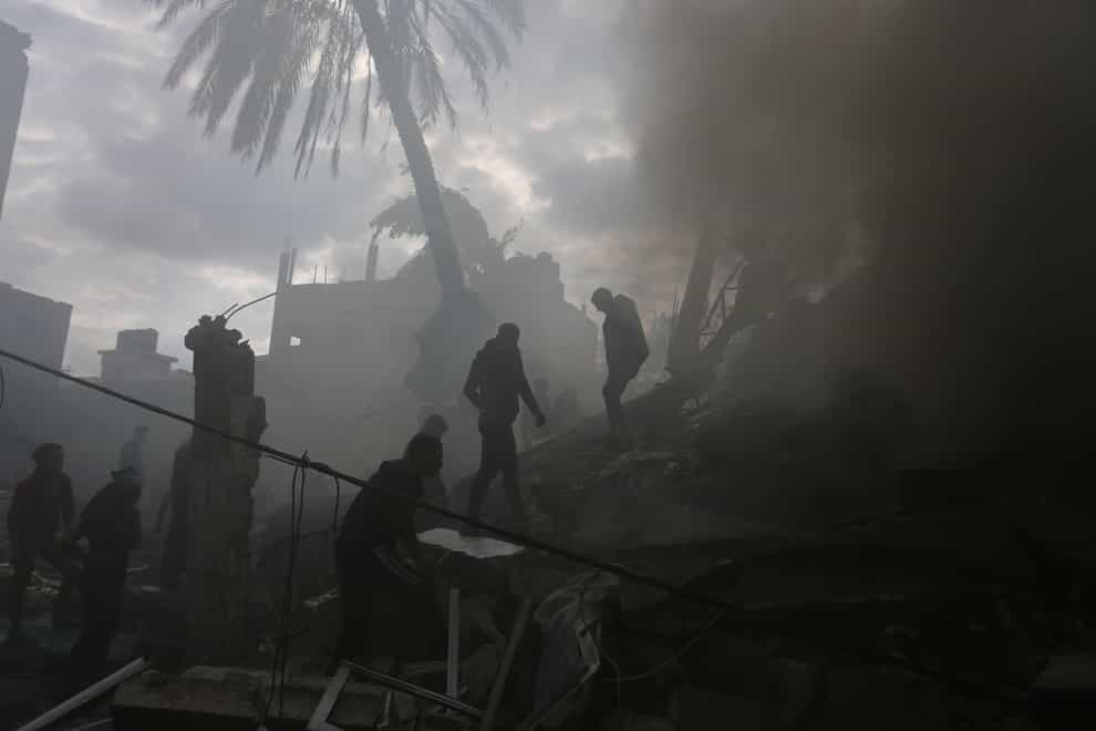 Palestinians look for the survivors of an Israeli strike in Rafah, Gaza Strip, on Thursday (Hatem Ali/AP)