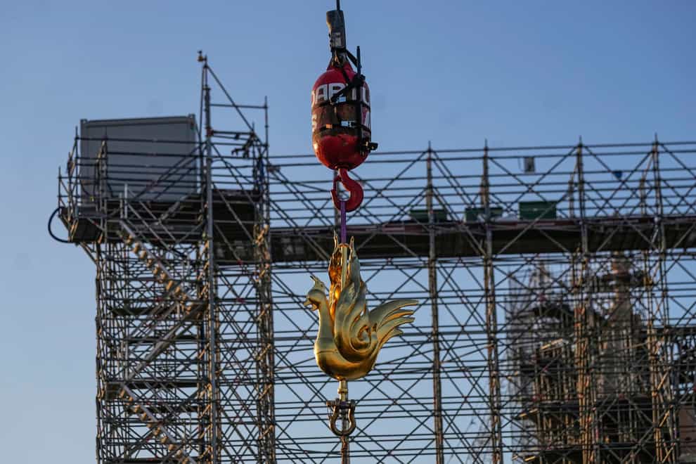 The golden rooster is craned up to the top of the Notre Dame cathedral spire (AP Photo/Michel Euler)