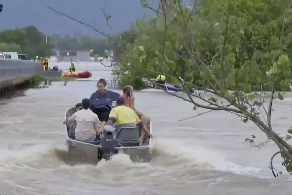 In this image from a video, people ride in boats in flooded river in Cairns, Australia (Australian Broadcasting Corp via AP)