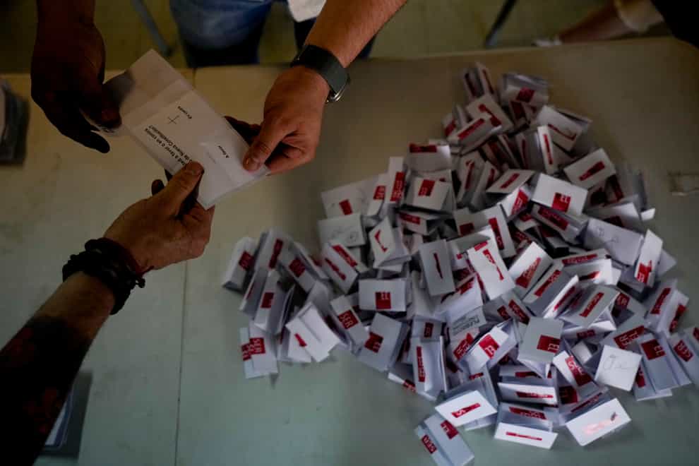 Electoral workers open ballots after the polls closed in Santiago (Esteban Felix/AP)