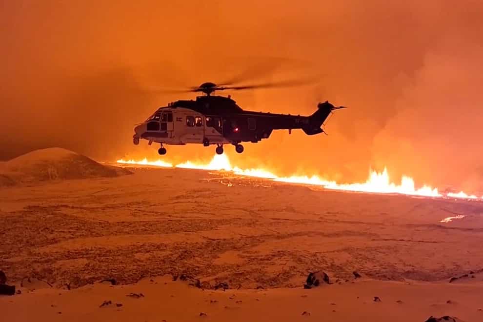 A coastguard helicopter flying near magma on a hill near Grindavik (Icelandic coastguard via AP)