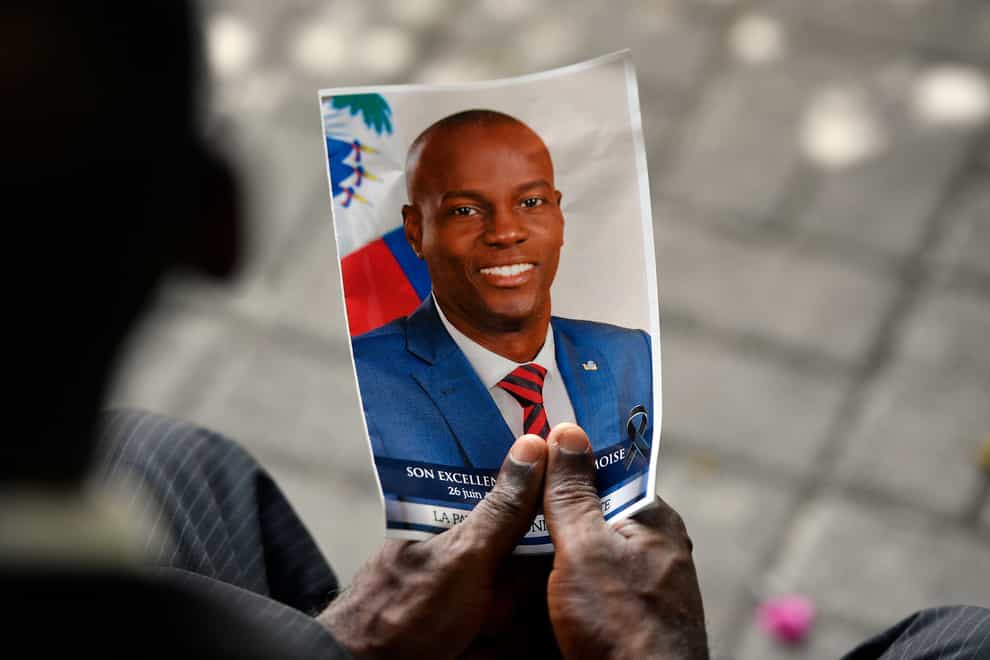 A person holds a photo of late Haitian President Jovenel Moise during his memorial ceremony (Matias Delacroix/AP)