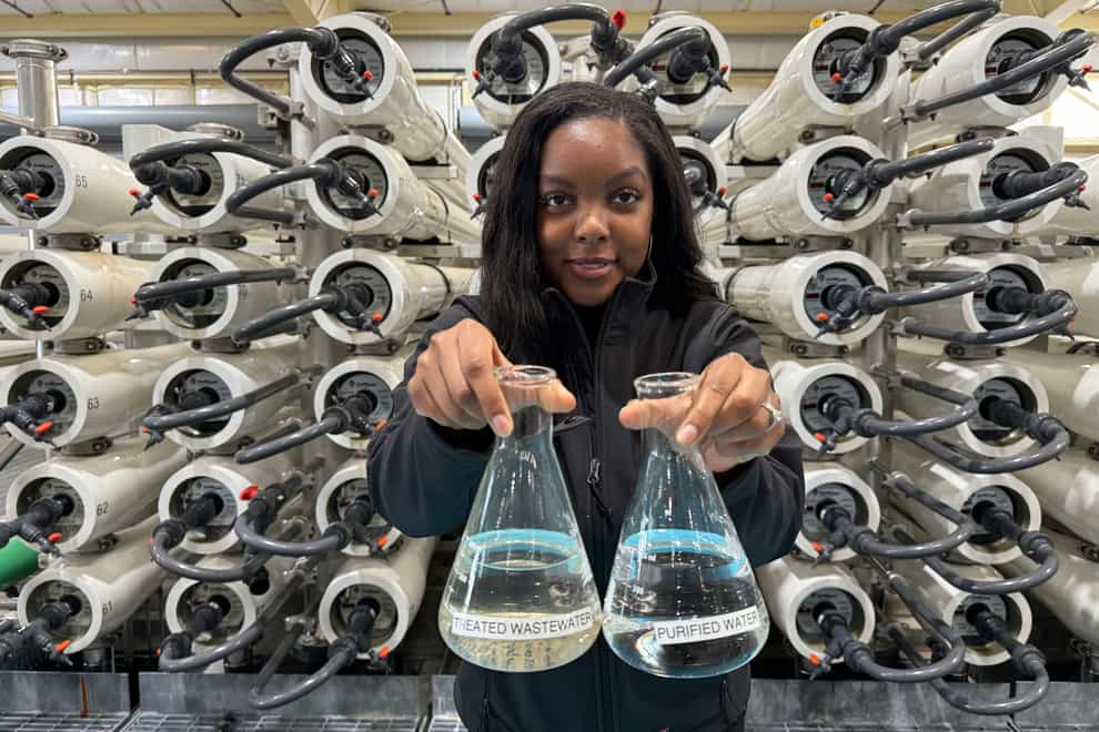 Lakeisha Bryant, public information representative at the Santa Clara Valley Water District, holds flasks of water before and after it is purified at the Silicon Valley Advance Purification Centre (Terry Chea/AP)