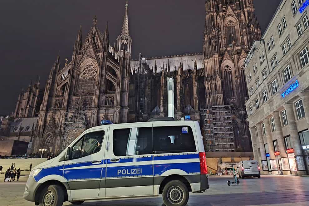 A police vehicle is parked in front of the cathedral in Cologne, Germany (Sascha Thelen/dpa via AP)