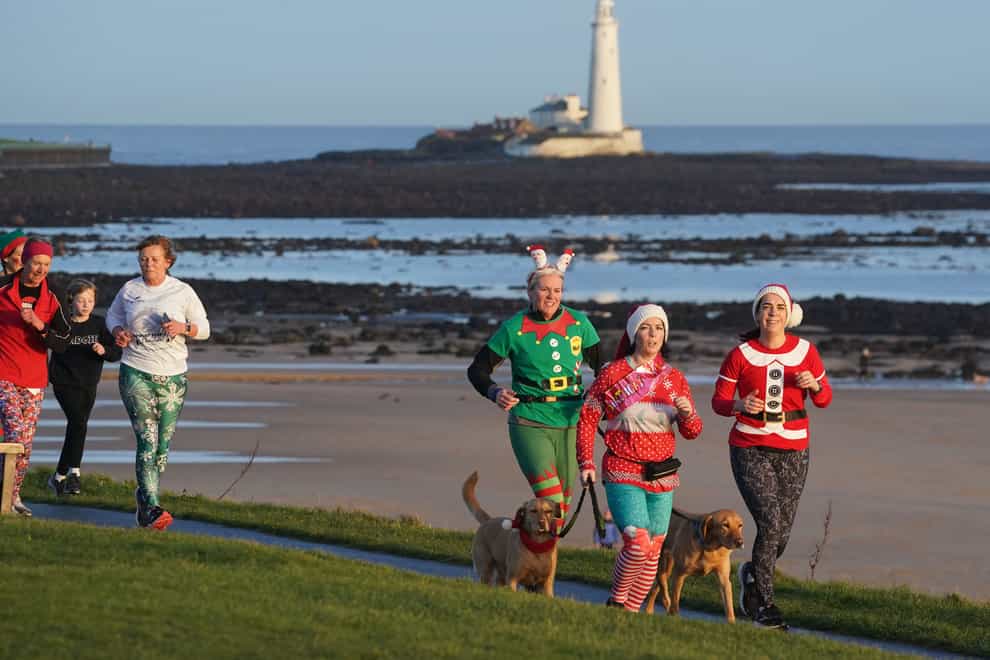 Runners dressed in festive outifits take part in the Christmas Eve park run at Whitley Bay in the North East of England (Owen Humphreys/PA)