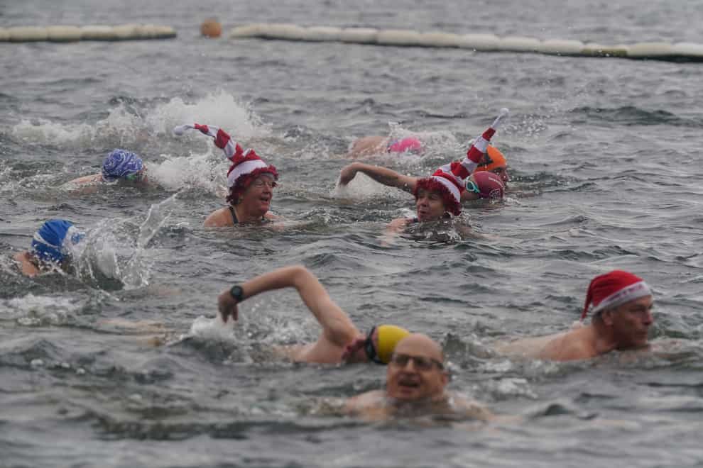 Members of the Serpentine Swimming Club take part in the Peter Pan Cup race, which is held every Christmas Day at the Serpentine, in Hyde Park, central London (Lucy North/PA)