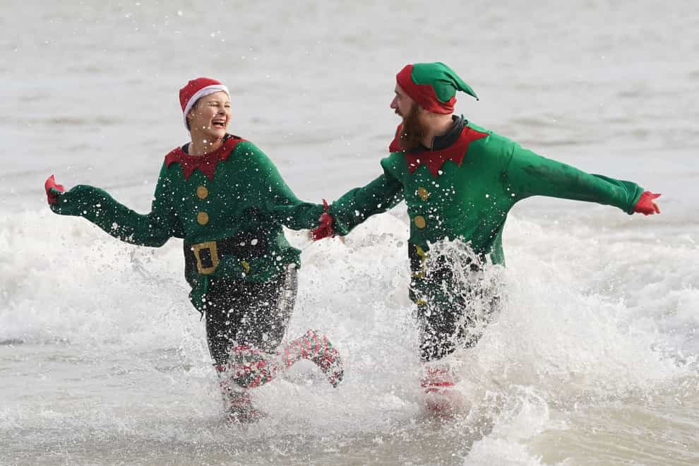 Swimmers take part in the Folkestone Lions’ Boxing Day Dip at Sunny Sands Beach in Folkestone, Kent (Gareth Fuller/PA)