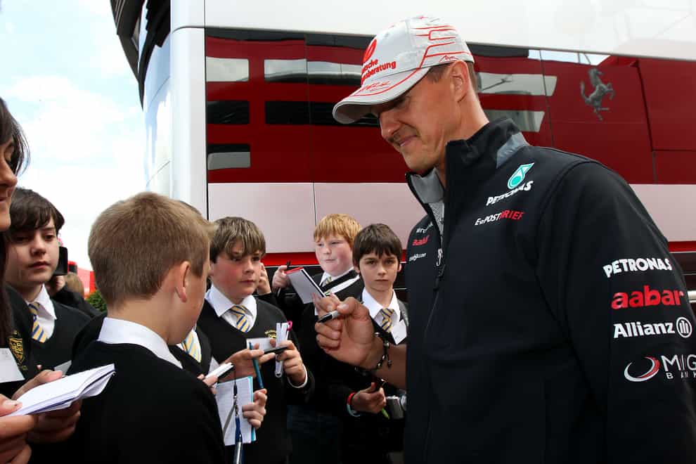 Michael Schumacher signs an autograph ahead of the British Grand Prix in 2012 (David Davies/PA)