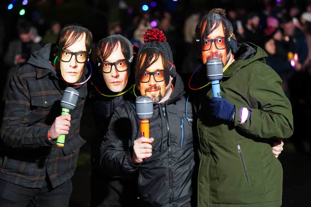 Revellers wear Jarvis Cocker masks ahead of Pulp playing at the New Year Hogmanay Street Party (Jane Barlow/PA)