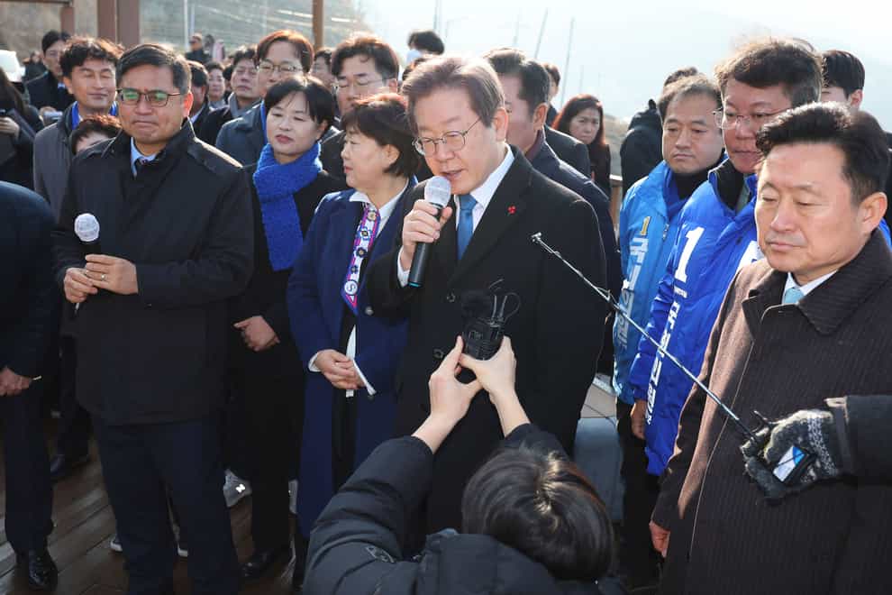 South Korean opposition leader Lee Jae-myung, centre, speaks as he visits the construction site of a new airport in Busan, South Korea (Sohn Hyung-joo/Yonhap via AP)