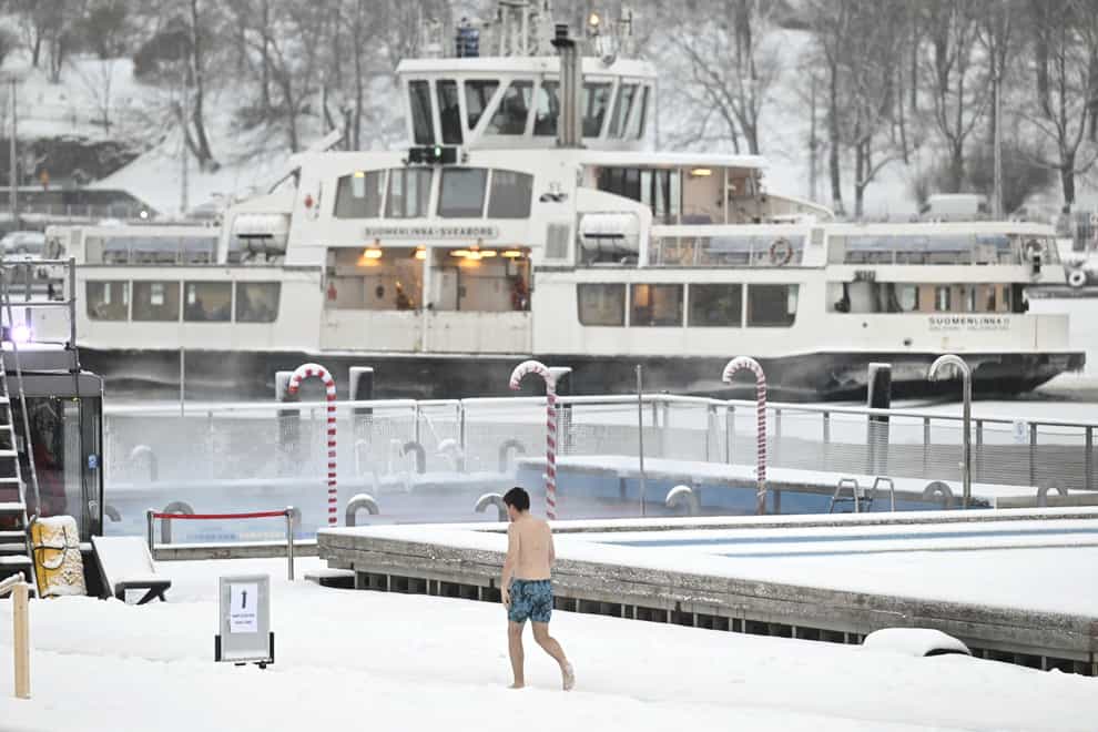 A man walks by the Allas Sea Pool, in Southern Helsinki, Finland, on Tuesday, as temperatures plummeted in the Nordic region. (Vesa Moilanen/Lehtikuva via AP)