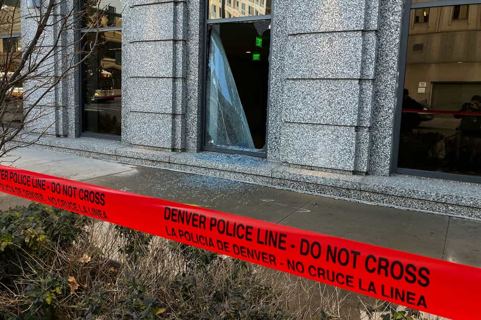Police line tape marks a broken window at the the Ralph L Carr Colorado Judicial Centre in Denver (Hyoung Chang/The Denver Post via AP)