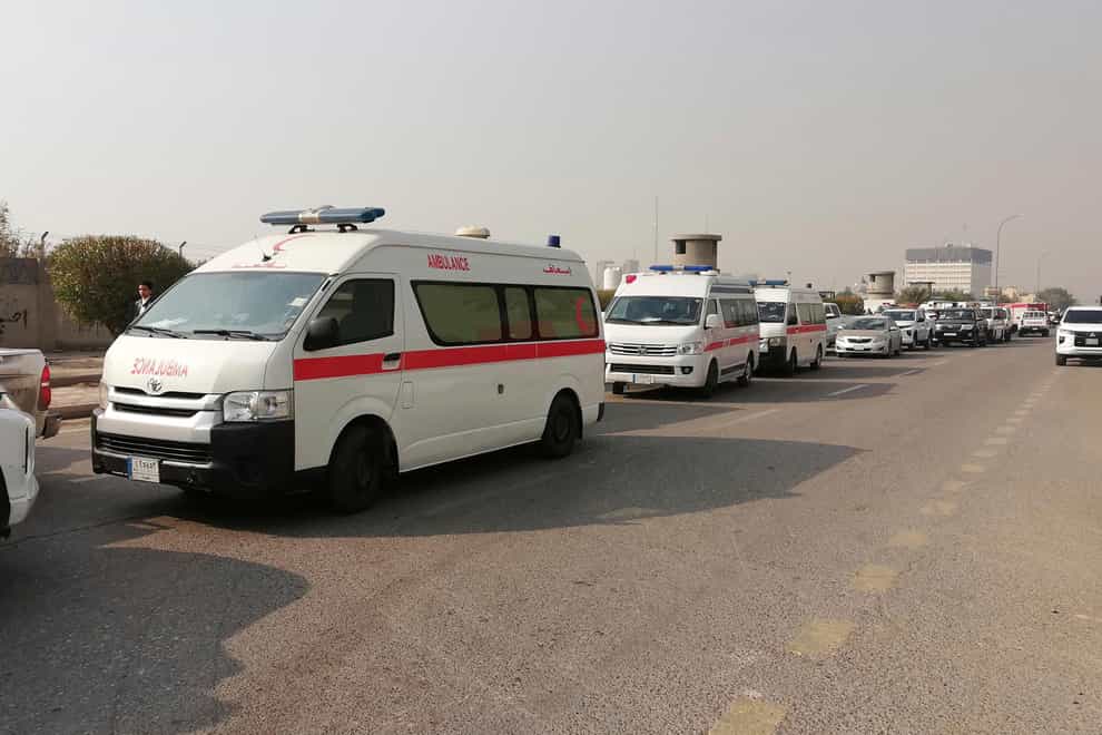 Ambulances line up in front of a headquarters of the Popular Mobilisation Force after it was hit by an airstrike in Baghdad on Thursday (Hadi Mizban/AP)