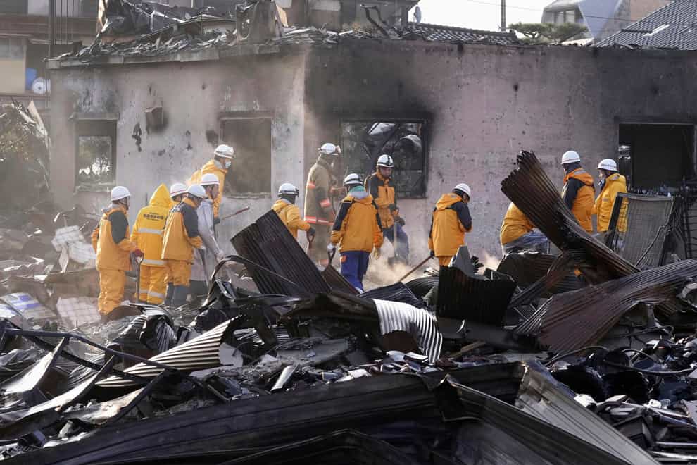 Firefighters remove the debris from a fire at a burned market in Wajima, Ishikawa prefecture (Kyodo News/AP)