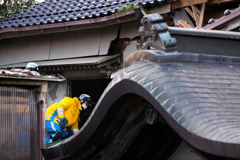 Police officers go into a building at the premises of a temple (AP Photo/Hiro Komae)
