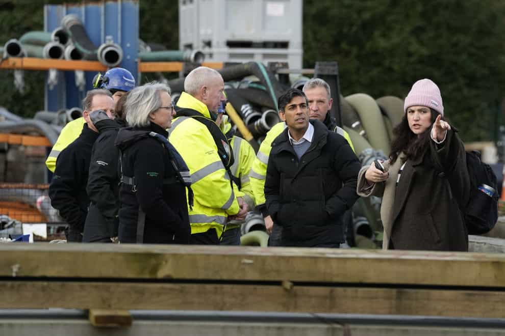 Rishi Sunak speaks to members of the Environment Agency as he looks at flood defences during a visit to Oxford (Frank Augstein/PA)