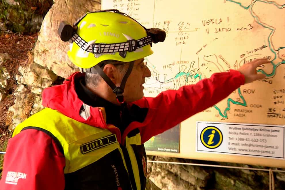 A rescuer inspects the map of the Krizna Jama cave near Grahovo, Slovenia (Pop TV via AP)
