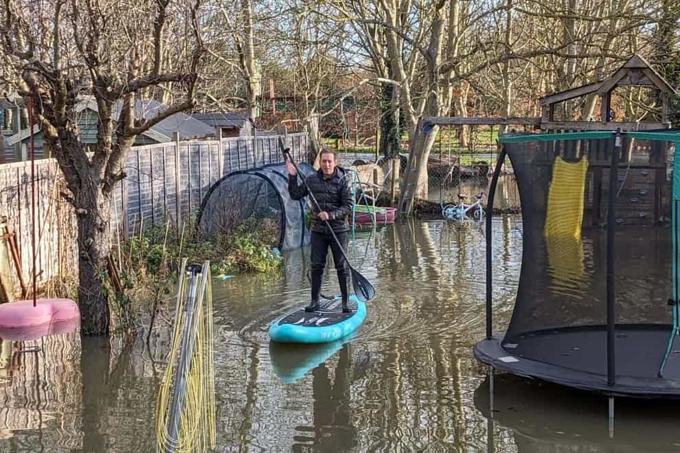 Michael Kneafsey on a paddleboard in his garden (Vanisha Kneafsey/PA)