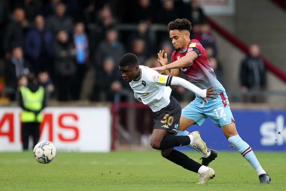 Salford City’s Kelly N’Mai and Scunthorpe United’s Jai Rowe (right) battle for the ball during the Sky Bet League Two match at Glanford Park, Scunthorpe. Picture date: Saturday November 13, 2021.