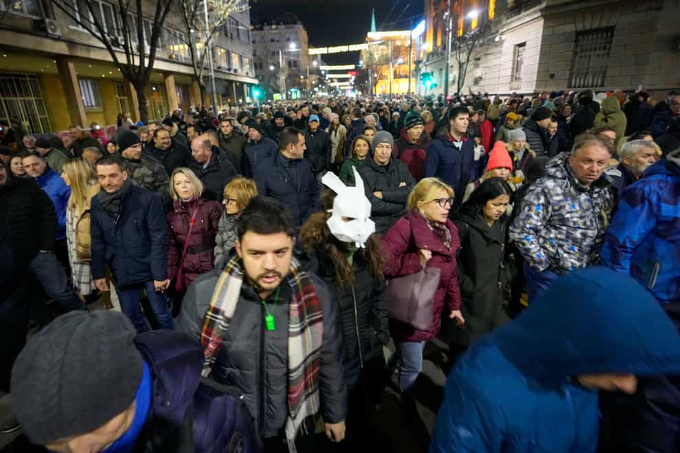 People march during a rally in Belgrade, Serbia, on Tuesday (Darko Vojinovic/AP)