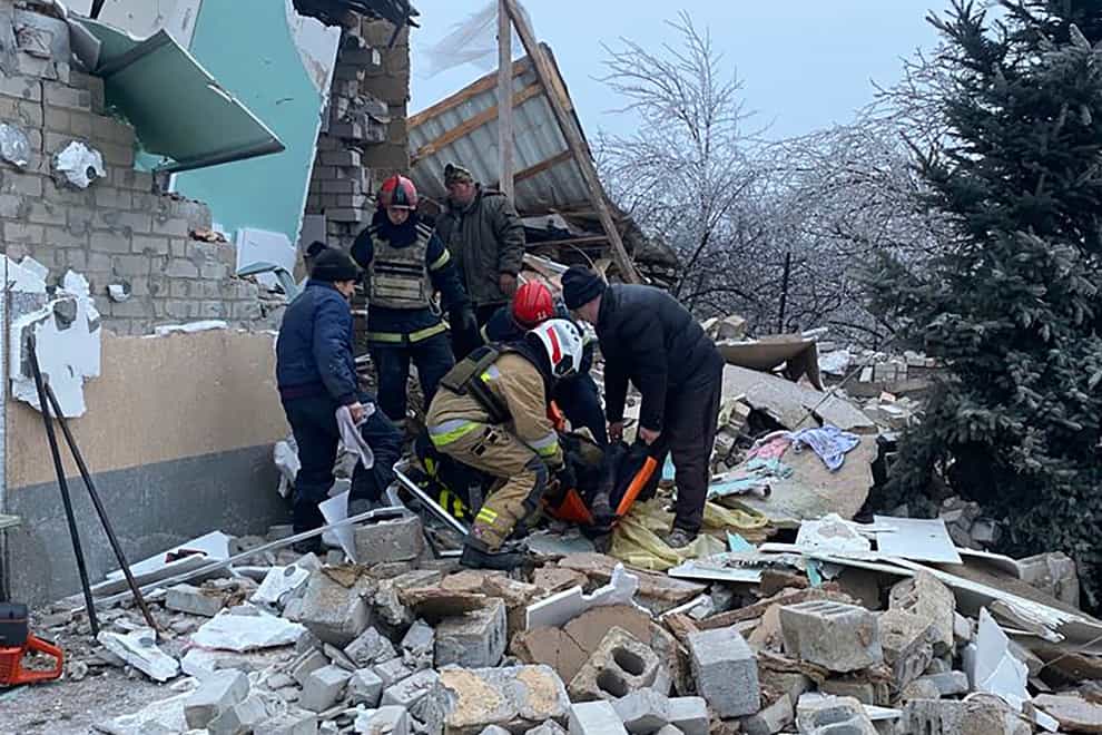 Photo provided by the Ukrainian Emergency Service showing rescuers help a wounded person after houses were destroyed by a Russian missile attack in Novomoskovsk, Ukraine (Ukrainian Emergency Service/AP)