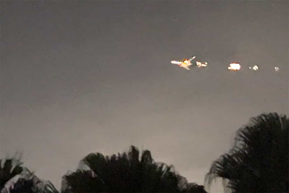 This image taken from video provided by Melanie Adaros shows sparks shooting from a cargo plane before making an emergency landing at Miami International Airport (Melanie Adaros via AP)