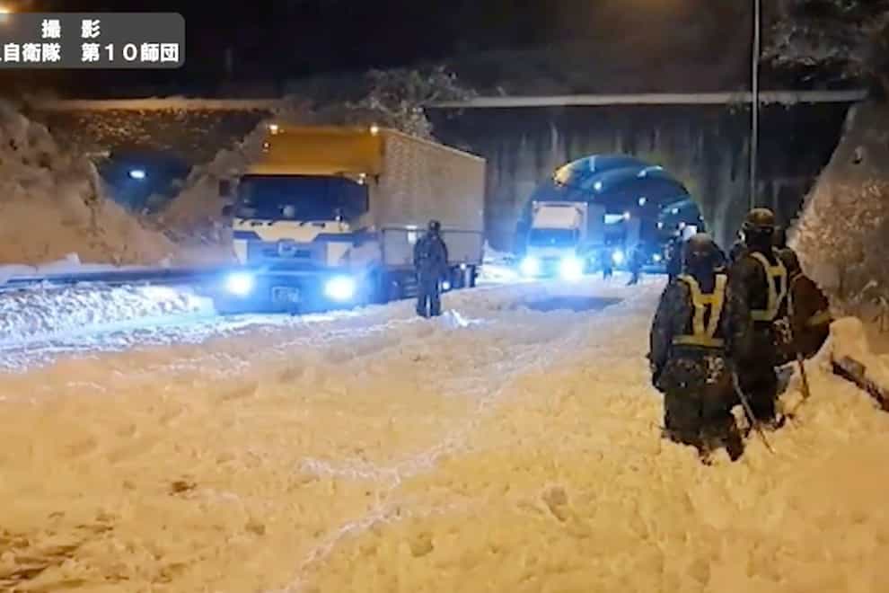 Hundreds of vehicles were stuck for hours on an expressway after the snow caused problems for drivers (Japan Ground Self-Defense Force via AP)