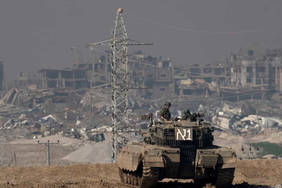 Israeli soldiers overlook the Gaza Strip from a tank, as seen from southern Israel (Maya Alleruzzo/AP)