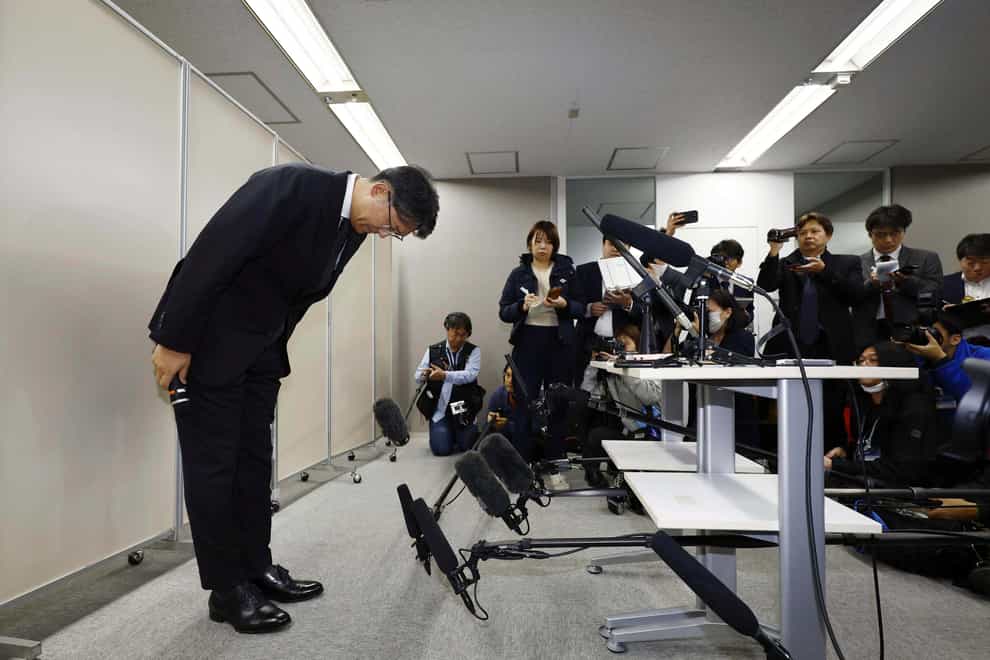 Mr Sato bowed as he made the apology (Kyodo News via AP)
