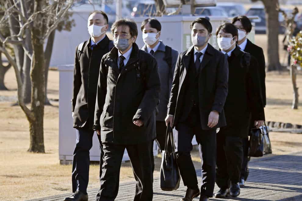 Japanese transport officials walk towards the Toyota factory in Hekinan, central Japan (Kyodo News via AP)