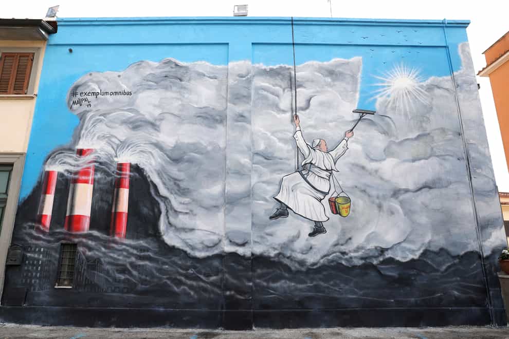 Graffiti depicting Pope Francis cleaning the sky from pollution (Andrew Medichini/AP)