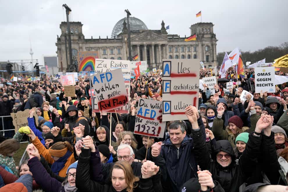 People hold hands in front of Germany’s parliament Reichstag at a demonstration against the AfD party and right-wing extremism in Berlin, Germany (Ebrahim Noroozi/AP)