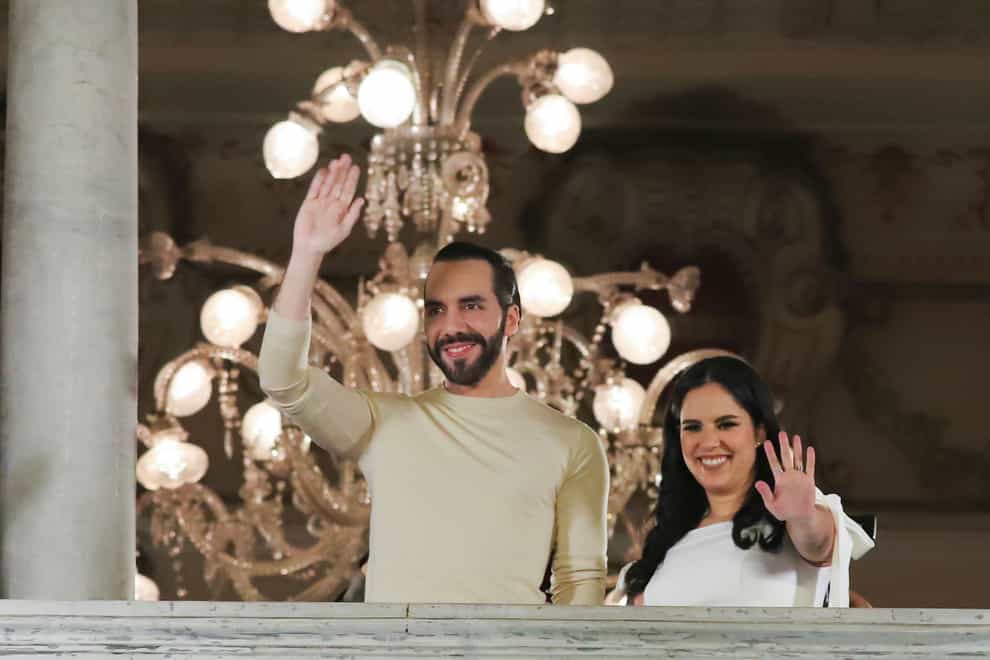 El Salvador’s President Nayib Bukele and his wife Gabriela Rodriguez wave to supporters from the balcony of the presidential palace in San Salvador, El Salvador, after polls closed (Salvador Melendez/AP)