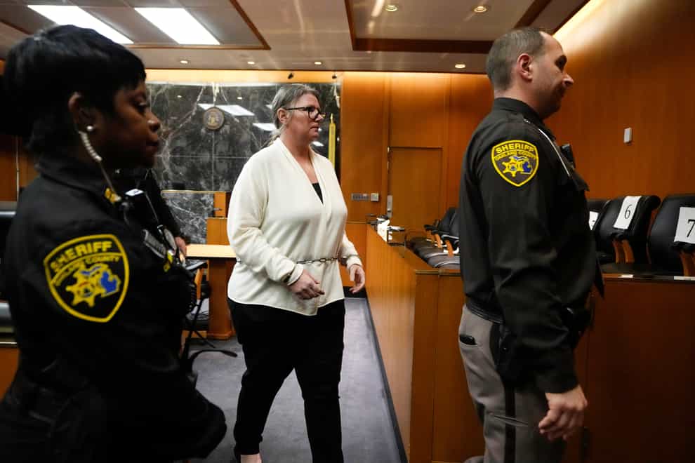 Jennifer Crumbley is escorted out of court in Pontiac, Michigan at an earlier hearing (Carlos Osorio/AP)
