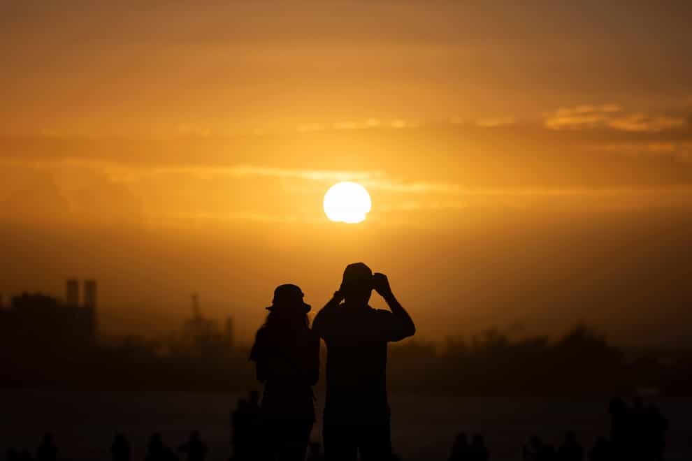 People watch the sunset during the San Sebastián Street festivities in San Juan, Puerto Rico on January 21 (AP)