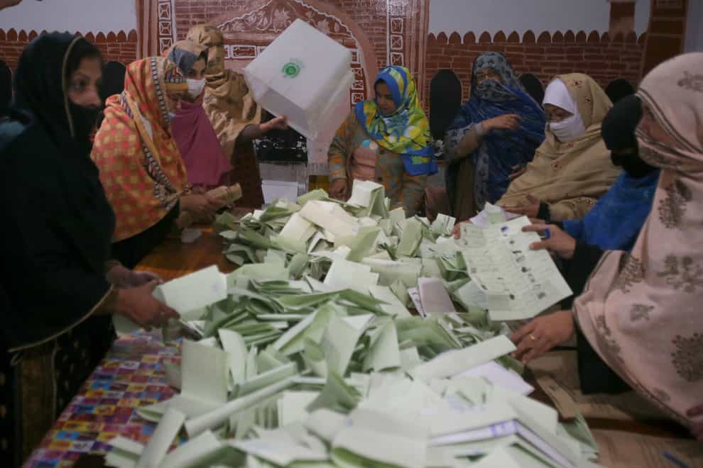 Members of polling staff count the votes after the polls closed for parliamentary elections, in Peshawar, Pakistan (Muhammad Sajjad/AP)