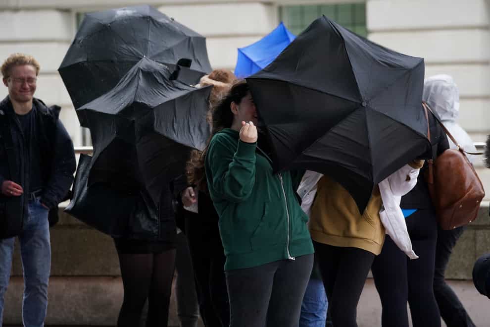 People struggle with their umbrellas during the wet and windy weather in Birmingham (Jacob King/PA)