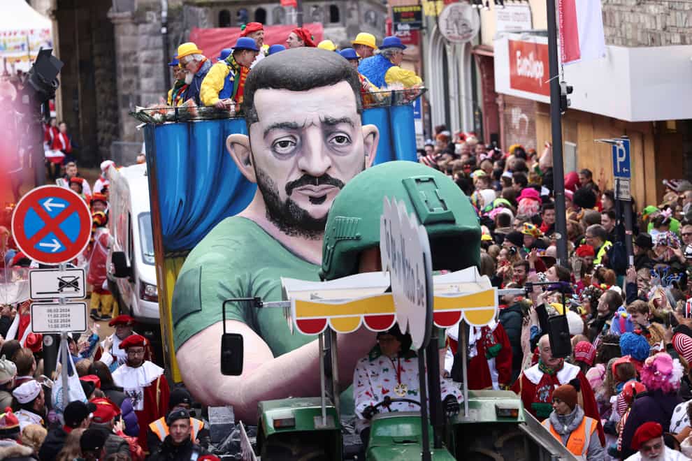 A float depicting Ukrainian President Volodymyr Zelensky is driven through the streets during the Rose Monday parade in Cologne (Rolf Vennenbernd/dpa via AP)