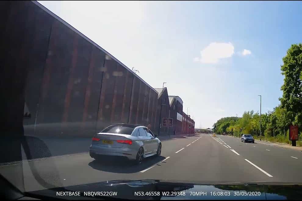 Handout screengrab issued by Greater Manchester Police from seized dash cam footage dated 30/5/2020 showing one of occupants of the cars waving at one of the other drivers (GMP/PA)